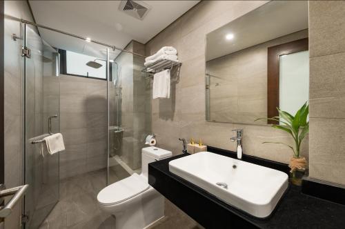 y baño con lavabo, aseo y espejo. en Hanoi Fiesta Grand Hotel and Spa, en Hanói