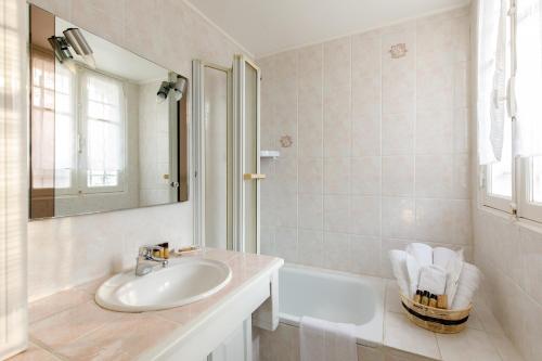 une salle de bain avec un lavabo, un miroir et une baignoire dans l'établissement Villa Carole YourHostHelper., à Roquebrune-sur Argens