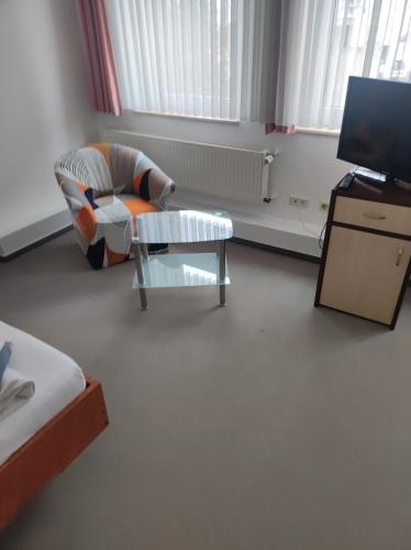 a living room with a chair and a tv at Zimmer am Jüdenhof in Heilbad Heiligenstadt