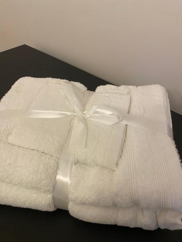 a stack of white towels with a ribbon on it at Apartament Timisoara 4 in Timişoara