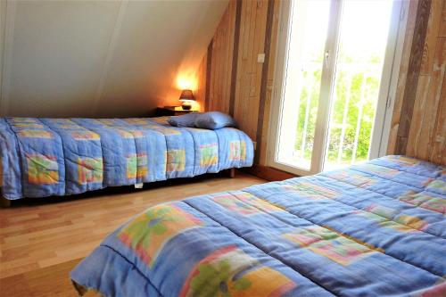 a bedroom with two beds and a window at La Balme in Loubressac