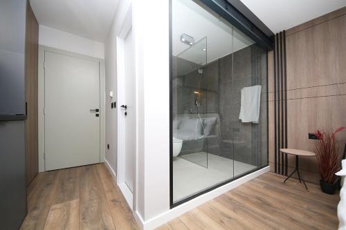 baño con ducha y puerta de cristal en Nest Apartments Sarajevo en Sarajevo
