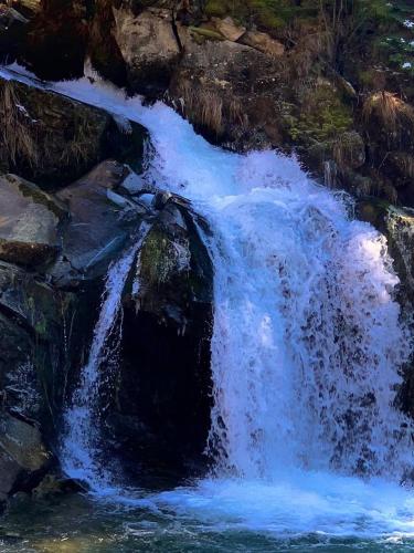a painting of a waterfall with blue water at Guest House Pid Dubom Карпати Під Дубом in Skole