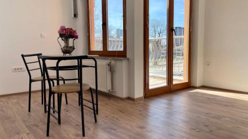 una mesa con dos sillas y un jarrón de flores. en Apartments Katrca Bežigrad, en Liubliana