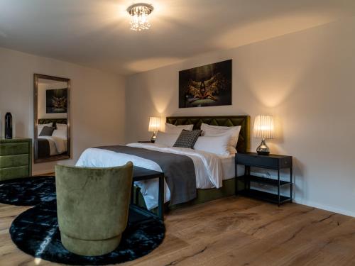 - une chambre avec un grand lit et une chaise dans l'établissement Suite Home Apartments, à Weimar