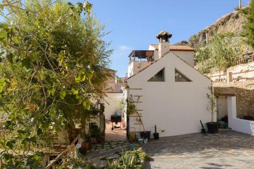 a white building with a cross on the side of it at El Encanto in Monachil