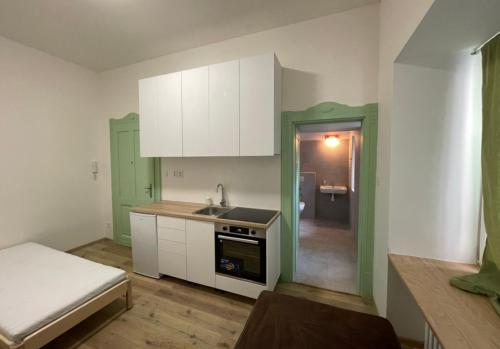 eine Küche mit weißen Schränken und einem Waschbecken in der Unterkunft Red&Black Apartment City centr, Na Hradbách 118 in Ostrava