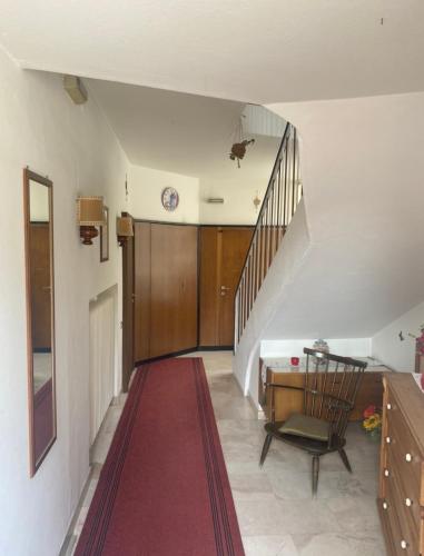 a hallway with a staircase and a table and a stair case at Hotel Villa Emilia in Ortisei