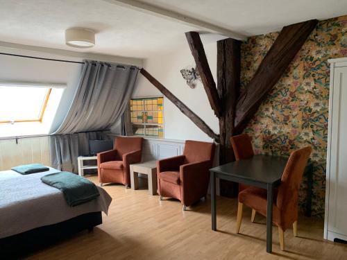 een slaapkamer met een bed en een tafel en stoelen bij Bed and Breakfast de Salix in Hitzum