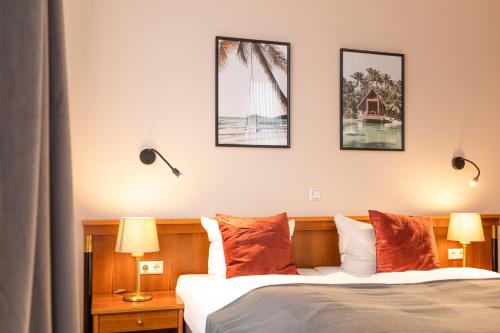 a bedroom with a bed with three pictures on the wall at Hotel Restaurant Am Park in Waltrop