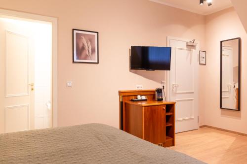 a bedroom with a bed and a flat screen tv at Hotel Restaurant Am Park in Waltrop