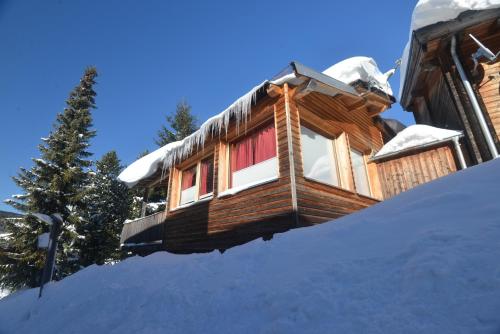 a log cabin with snow on the ground at Feriendorf Tauerngast in Hohentauern