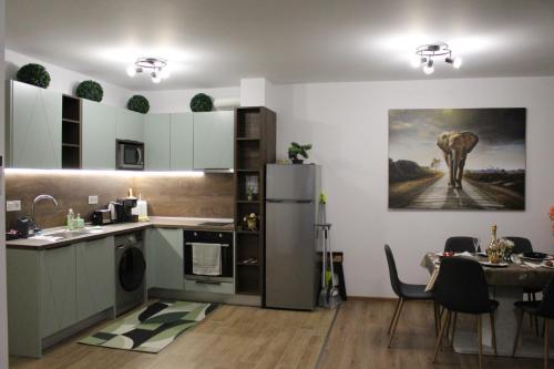 eine Küche mit einem Kühlschrank und einem Tisch darin in der Unterkunft ARIAL -Топ Център Варна in Warna