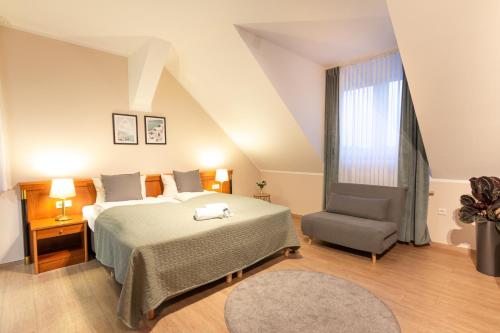 a bedroom with a large bed and a chair at Hotel Restaurant Am Park in Waltrop