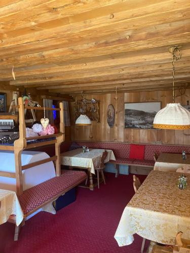 a room with tables and chairs in a room with wooden ceilings at Hotel Villa Emilia in Ortisei