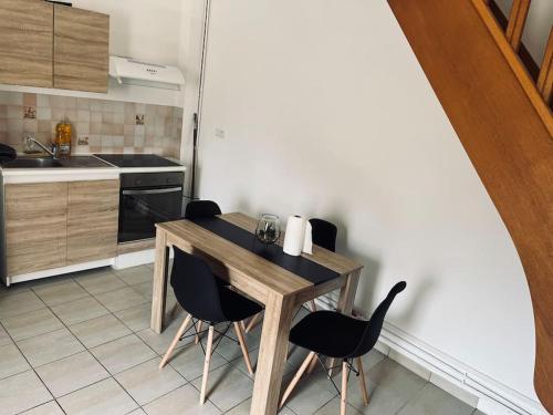 une cuisine avec une table en bois et des chaises noires dans l'établissement Bel appartement duplex - Nogent hypercentre, à Nogent-sur-Seine