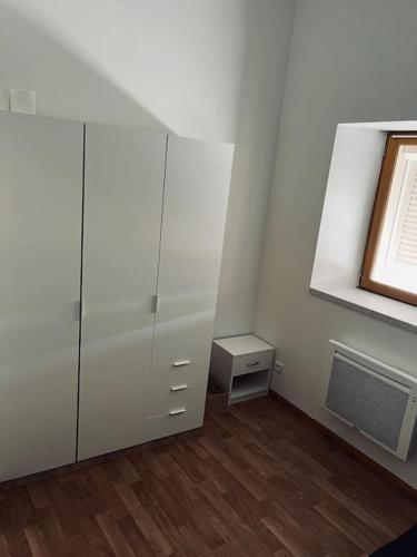 Cette chambre comprend une armoire blanche et une fenêtre. dans l'établissement Bel appartement duplex - Nogent hypercentre, à Nogent-sur-Seine