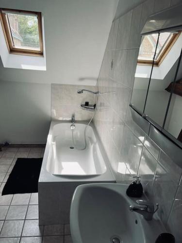 une salle de bain blanche avec une baignoire et un lavabo dans l'établissement Bel appartement duplex - Nogent hypercentre, à Nogent-sur-Seine