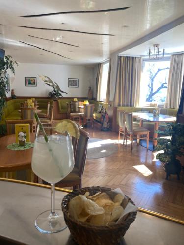 a table with a drink and a basket of bread at Hotel Villa Emilia in Ortisei