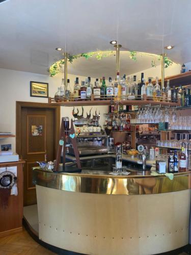 a bar with a counter with a lot of alcohol at Hotel Villa Emilia in Ortisei