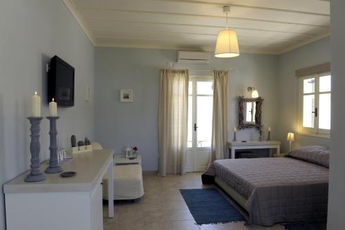 a bedroom with a bed and a television in it at Almyris in Adamantas