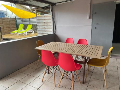 mesa y sillas en una habitación con mesa en Ti Caz de Ness, en Saint-Leu