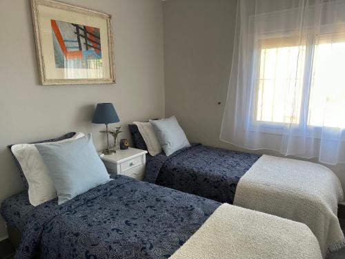 a bedroom with two beds and a window at Detached holiday house, 2 bedrooms, private garden, pool in Alhaurín de la Torre