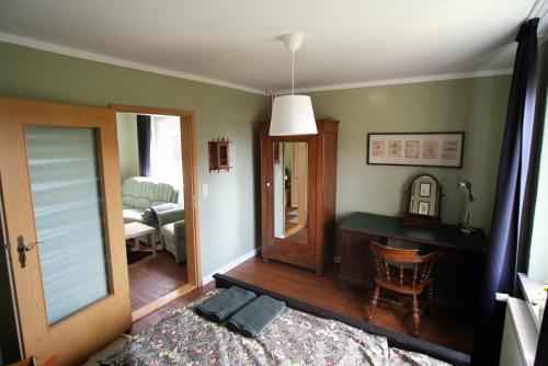 Schlafzimmer mit einem Bett und einem Schreibtisch mit einem Spiegel in der Unterkunft „Grüne Höhle“ in Schwerin in Schwerin