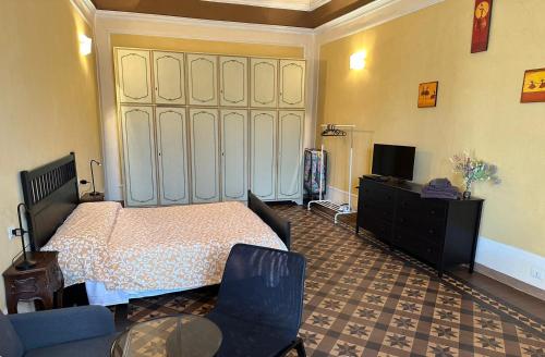 a bedroom with a bed and a tv and a couch at Casa Cavour in Pontremoli