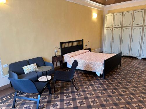 a bedroom with a bed and a couch and chairs at Casa Cavour in Pontremoli