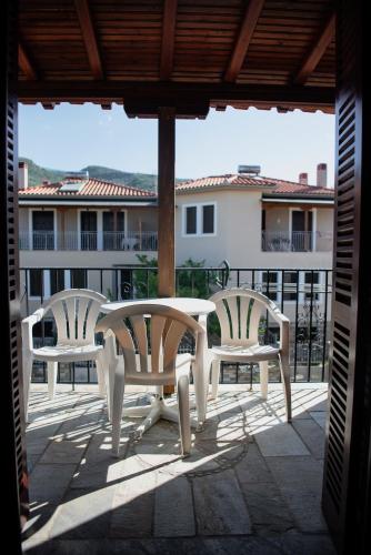 two white chairs and a table on a patio at Studio Sevasti in Kala Nera