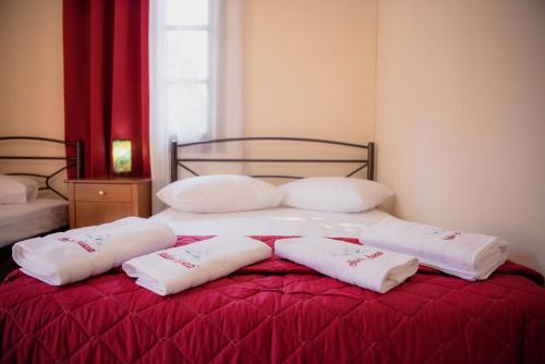 a bed with three white pillows on top of it at Studio Sevasti in Kala Nera