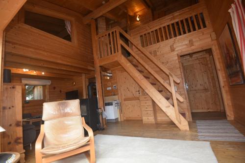 a room with a staircase in a cabin with a chair at Feriendorf Tauerngast in Hohentauern