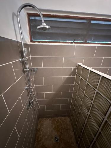 a shower in a tiled bathroom with a window at Mana - SRFB 2 in Mana