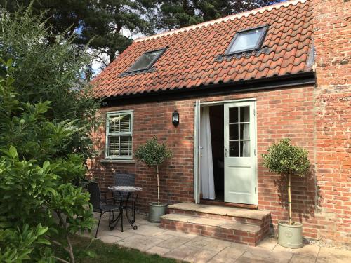 a red brick house with a white door and a table at White House Barn, near Yarm / Stockton-on-Tees in Yarm