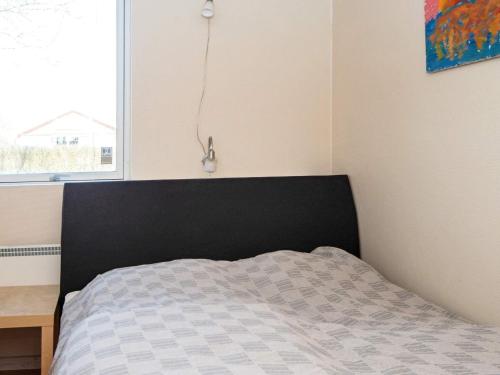 a bedroom with a bed with a black headboard and a window at 8 person holiday home in Struer-By Traum in Struer