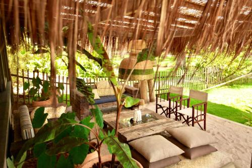 a patio with chairs and a table and some plants at Aldeia do Mar Sensorial Hotel in Itacaré