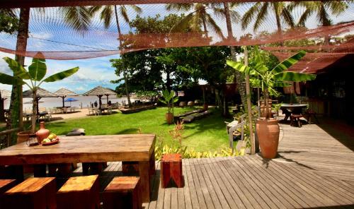 a wooden deck with a table and a picnic table at Aldeia do Mar Sensorial Hotel in Itacaré