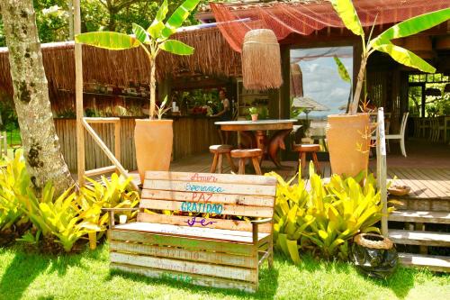 a bench sitting in the grass in front of a restaurant at Aldeia do Mar Sensorial Hotel in Itacaré