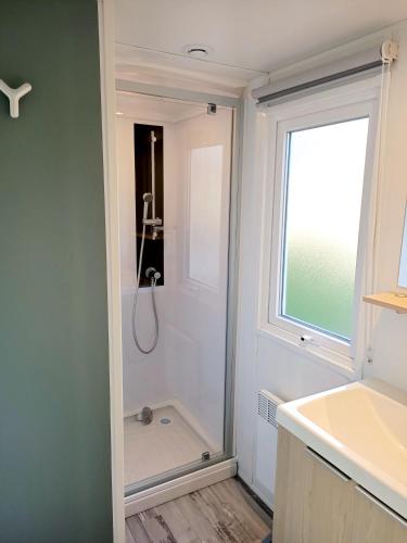 une salle de bain avec une douche et un lavabo et une fenêtre dans l'établissement Bungalow charmant à Onzain avec piscine partagée, à Onzain
