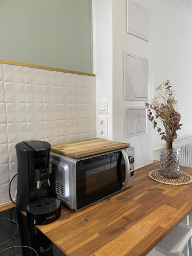 Un four micro-ondes est installé au-dessus d'une table en bois. dans l'établissement Studio Royan centre, à Royan