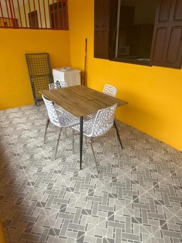 a table and chairs in a room with a yellow wall at Mana - SRFB 2 in Mana