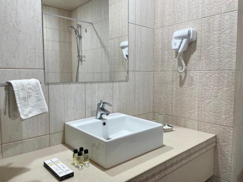 y baño con lavabo y ducha. en Hotel Gloria Deluxe en Borovoye