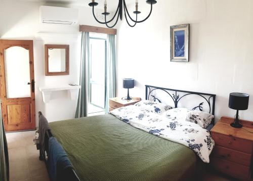 1 dormitorio con cama y lámpara de araña en B&b Seaview terrace en Għajnsielem