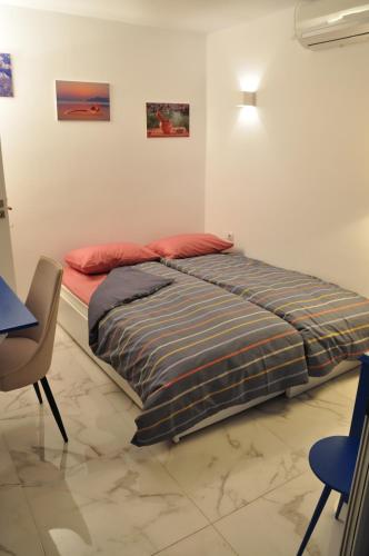 een slaapkamer met een bed en een stoel en enkele foto's bij Taratsaki in Athene