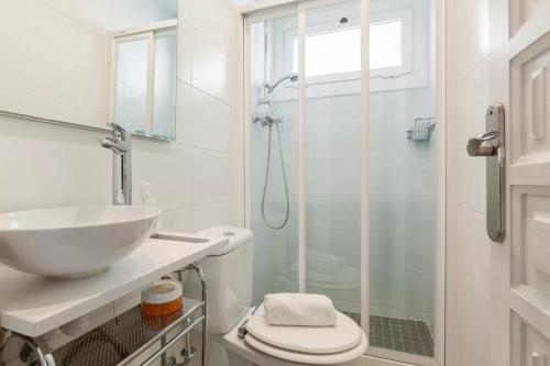 La salle de bains blanche est pourvue d'un lavabo et d'une douche. dans l'établissement Apartment Muralla, à Vilassar de Mar
