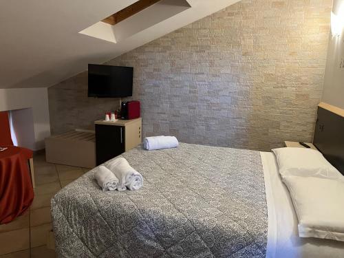 a bedroom with a bed with towels on it at Cascina Graziosa in Lonato del Garda