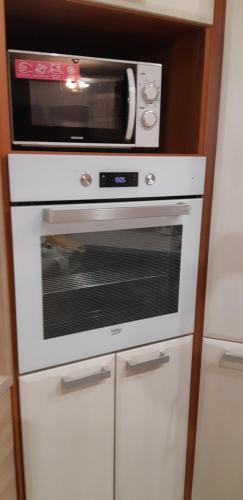 a microwave sitting on top of a white oven at Apartman YVET in Sučany