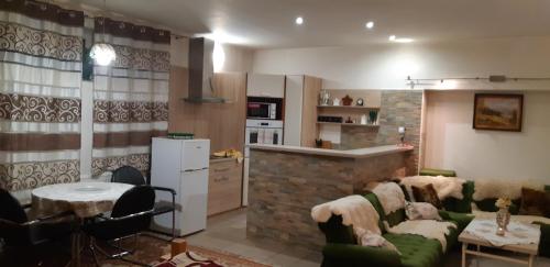 a living room with a couch and a kitchen at Apartman YVET in Sučany