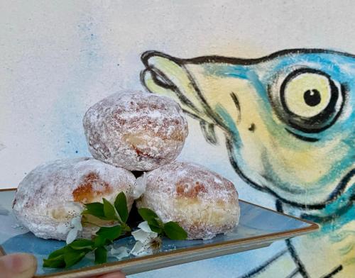 two donuts on a plate with a painting at Pensiunea Știuca Șchioapă in Băltenii de Sus